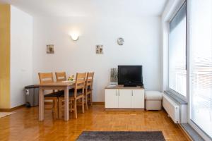 une salle à manger avec une table et une télévision dans l'établissement Apartma Luna, à Kranjska Gora