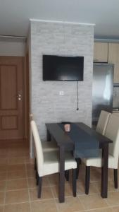 a black table with white chairs and a television on a wall at Juli Vendégház in Abádszalók