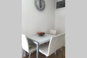 a white table with white chairs and a bowl on it at Centre ville Colmar, parking in Colmar