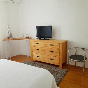 1 dormitorio con cama y vestidor con TV en Chambre d hotes "Lilimyna" avec petit déjeuner en Barjols