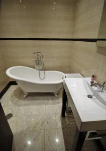 a bath tub and a sink in a bathroom at Casa70 in Setúbal