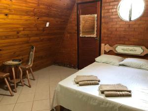 um quarto com 2 camas e toalhas em Chalés Verde Vida em Conservatória