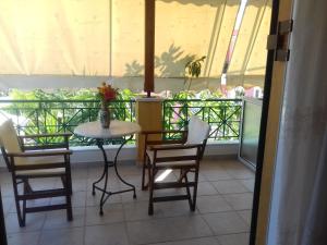 a table and chairs in a room with a balcony at Lenia Studios in Kalamitsi +52 photos