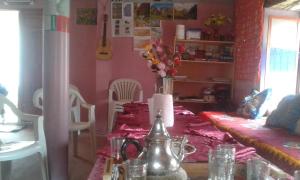 a dining room with a table with a vase of flowers at Gîte Baraka Taghia in Taghia