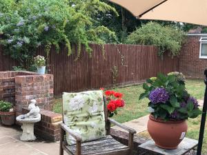 a garden with a chair and flowers and a fence at Wynchlands 4 Bedroom House in St Albans City in Saint Albans