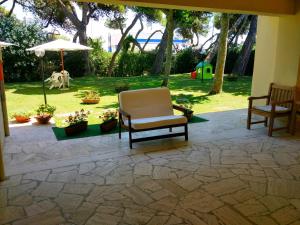 a patio with two chairs and an umbrella at B&B Il Parco Dei Pini in Giulianova