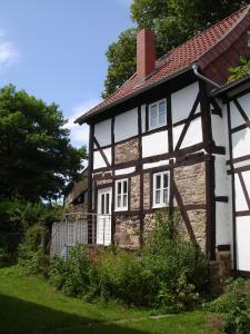 ein altes Steinhaus mit rotem Dach in der Unterkunft Ferienhaus am Solling in Dassel