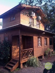 a wooden house with a porch and stairs in front of it at Posada de los Árboles in Eldorado