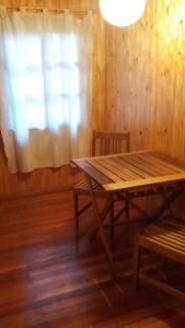 a wooden table and bench in a room with a window at Posada de los Árboles in Eldorado