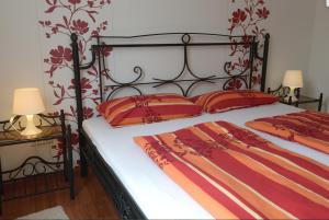 a bedroom with a bed with red and orange pillows at Ferienhaus Moselblick mit kostenfreien ÖPNV-Ticket in Ürzig