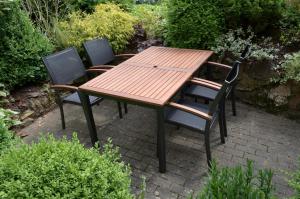 a wooden table and chairs on a brick patio at Ferienhaus Moselblick mit kostenfreien ÖPNV-Ticket in Ürzig