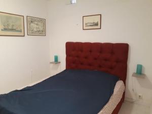 a bed in a room with a red headboard at Mykonos Beachfront House with Sunset & Delos View in Agios Stefanos