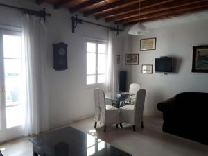 a living room with a glass table and chairs at Mykonos Beachfront House with Sunset & Delos View in Agios Stefanos