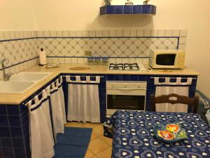a small kitchen with a sink and a stove at La Casetta di Ninetta in Ustica +25 photos