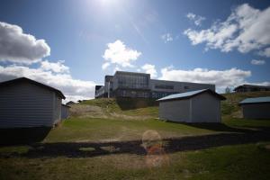 un grand bâtiment au sommet d'une colline avec des maisons dans l'établissement Efri-Vík Bungalows, à Kirkjubæjarklaustur