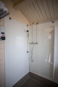 a room with a white wall and a shower at Efri-Vík Bungalows in Kirkjubæjarklaustur