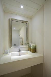
a bathroom with a sink, mirror and bath tub at Mahona Boutique Hotel in Las Terrenas
