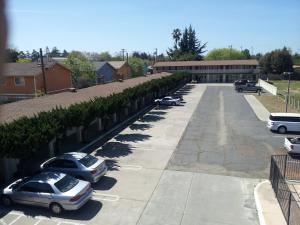 two cars parked in a parking lot in front of a building at El Rancho Motel Lodi in Lodi