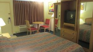 pokój hotelowy z łóżkiem i telewizorem w obiekcie El Rancho Motel Lodi w mieście Lodi
