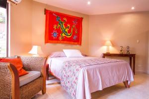 1 dormitorio con 1 cama y una pintura roja en la pared en Tamarindo Village Hotel, en Tamarindo