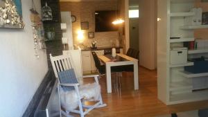 uma cozinha e sala de jantar com uma mesa e uma cadeira em Ferienappartment "Mili am See" em Lochau