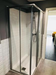 a shower with a glass enclosure in a bathroom at Apartamentos Arriba by gaiarooms in Salamanca