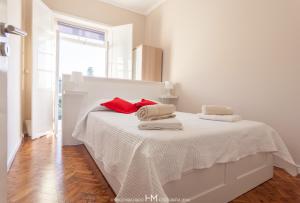 biała sypialnia z łóżkiem i ręcznikami w obiekcie Casa da Muralha w mieście Angra do Heroísmo