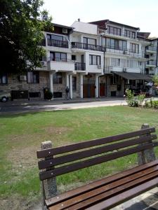 um banco de parque em frente a um grande edifício em Hotel Tony em Nessebar