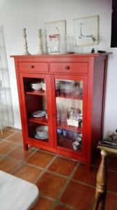 un armario rojo con platos y platos. en Las Casucas de Gema en Isla
