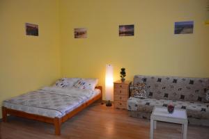 1 dormitorio con cama, sofá y mesa en Miracool Apartament, en Cracovia