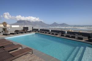 a swimming pool on the roof of a hotel with a smoking at Lagoon Beach 136 by CTHA in Cape Town