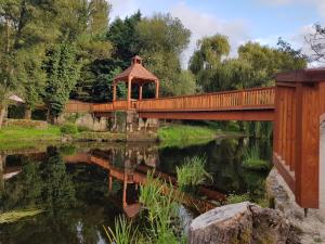 a bridge over a pond with a gazebo in a park at Casa García in Allariz