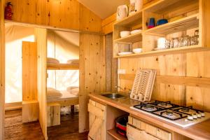 a kitchen with a sink and a stove in a cabin at SunFlower Camping Savudrija in Savudrija