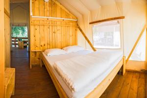 Cette chambre comprend un grand lit et une fenêtre. dans l'établissement SunFlower Camping Savudrija, à Savudrija