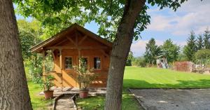 a tiny house in a park with trees at Kerka-Völgyi Vendégház in Kerkaszentkirály