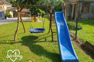 a playground with a blue slide in a yard at Kerka-Völgyi Vendégház in Kerkaszentkirály