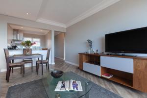 a living room with a flat screen tv and a table at Warren Heights 503 by CTHA in Cape Town