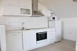 a white kitchen with white cabinets and a sink at Apartments Villa Milna 1 in Budva