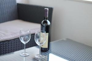 a bottle of wine and two wine glasses on a table at Apartments Villa Milna 1 in Budva