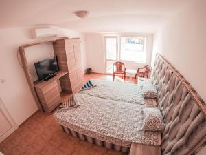 Habitación pequeña con cama y TV. en Guest House Gabriel, en Sozopol