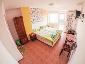 a bedroom with a bed and a window and a chair at Guest House Gabriel in Sozopol