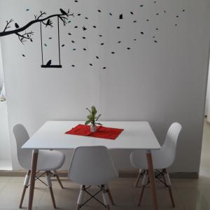 ein weißer Esstisch mit einem weißen Tisch mit einem Baum und abgestrichenen Vögeln in der Unterkunft Departamento Albaluz Barrio Sur in San Miguel de Tucumán