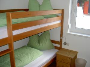 a bunk bed with green pillows and a window at Appartement Christopherus in Pettneu am Arlberg