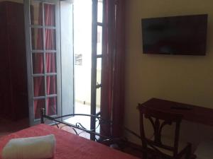 una camera con letto, televisore e tavolo di Guest House Capitan Libeccio a Tropea