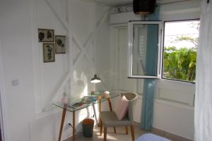 Habitación con escritorio y ventana. en Or bleu-Bungalow volcan Soufriere-Vue sur mer, en Saint-Claude