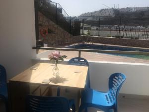 a table with blue chairs and a vase with flowers on it at Sunny Apartment Puerto Rico in Puerto Rico de Gran Canaria