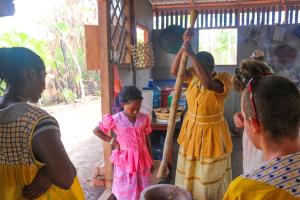 eine Gruppe von Menschen, die mit einer Frau um eine Küche stehen in der Unterkunft Palmento Grove Garifuna Eco-Cultural & Healing Institute in Hopkins