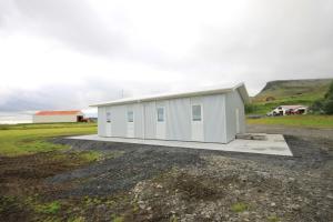 a white building on the side of a field at Selfell Guesthouse by Stay Iceland in Kálfafell