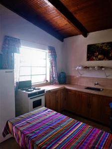 a kitchen with a stove and a sink and a window at Pink house in San Lucas Tolimán