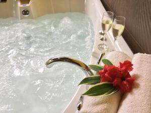 ein Badezimmer mit einer Badewanne und 2 Gläsern Champagner in der Unterkunft Oasi in Cahuita